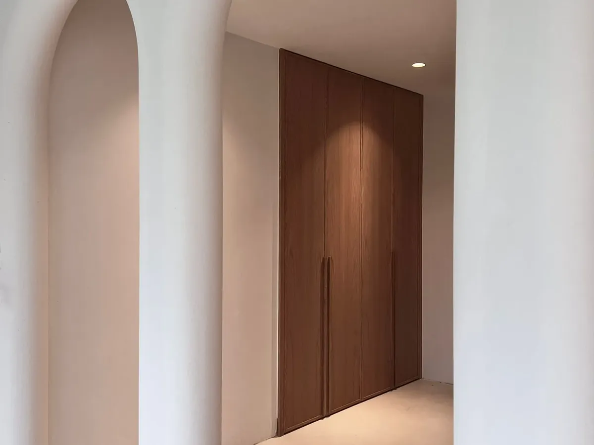Arche en plâtre et portes en bois dans un couloir aux finitions soignées