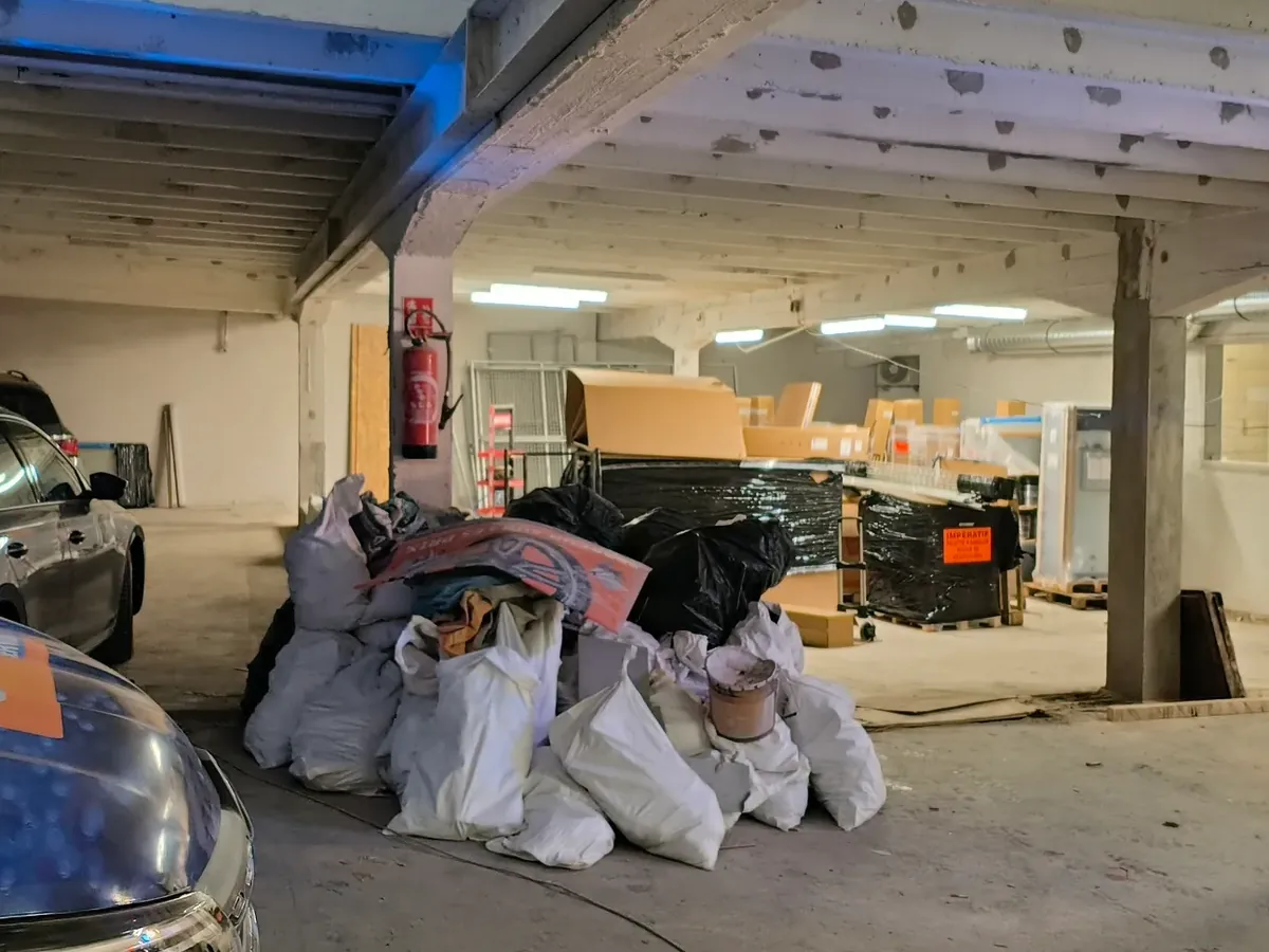 Grand local en travaux avec gravats et chariot élévateur avant aménagement commercial