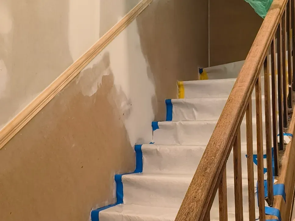 Cage d'escalier protégée par un film de chantier pendant la remise en état d'un logement