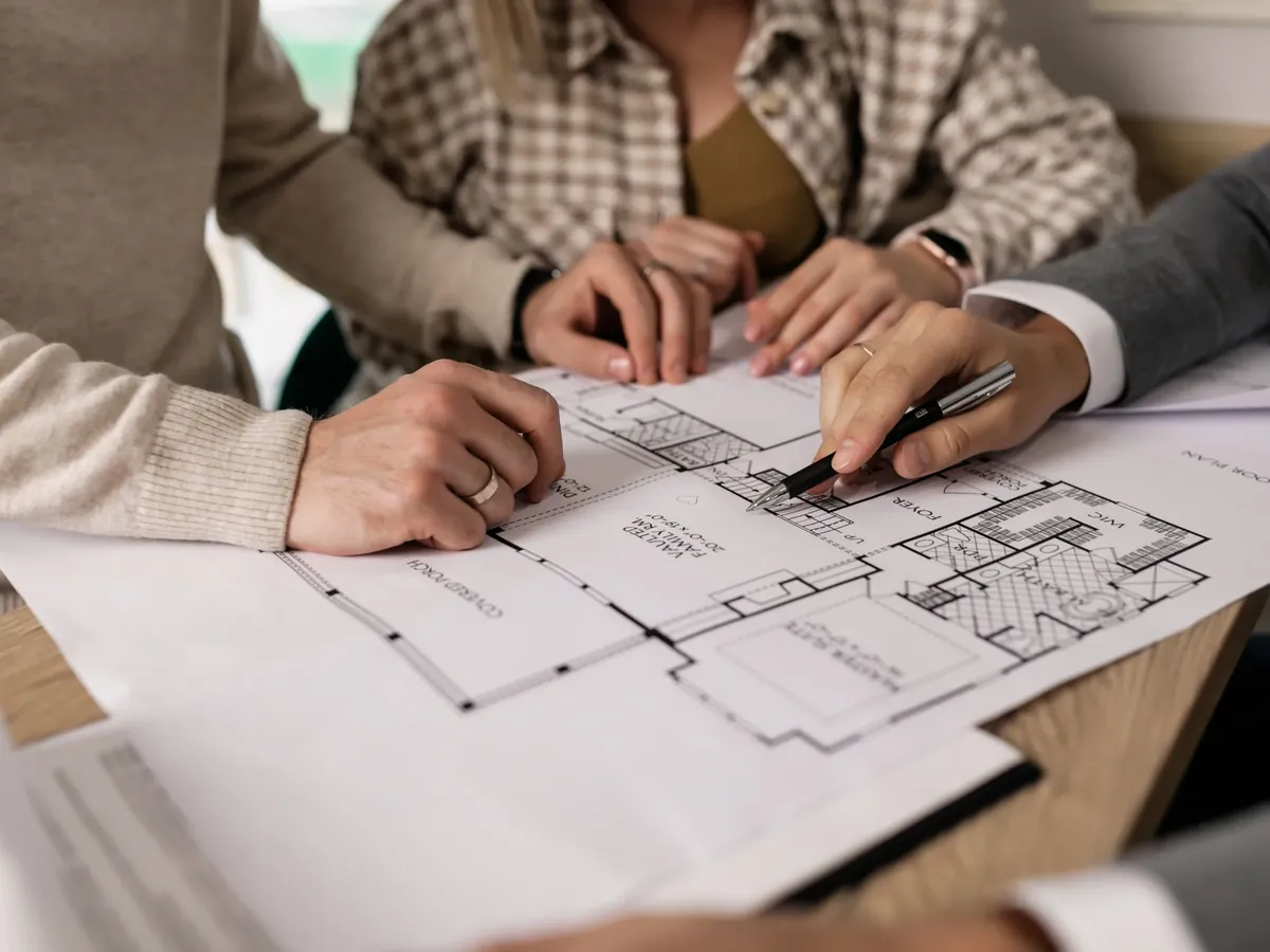 Équipe annotant un plan lors d'une réunion de suivi de chantier